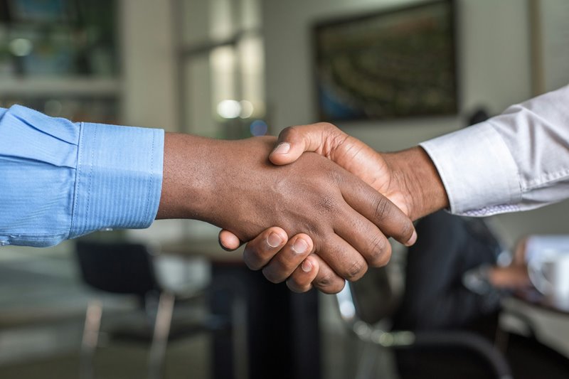 A hiring manager and job candidate shake hands.